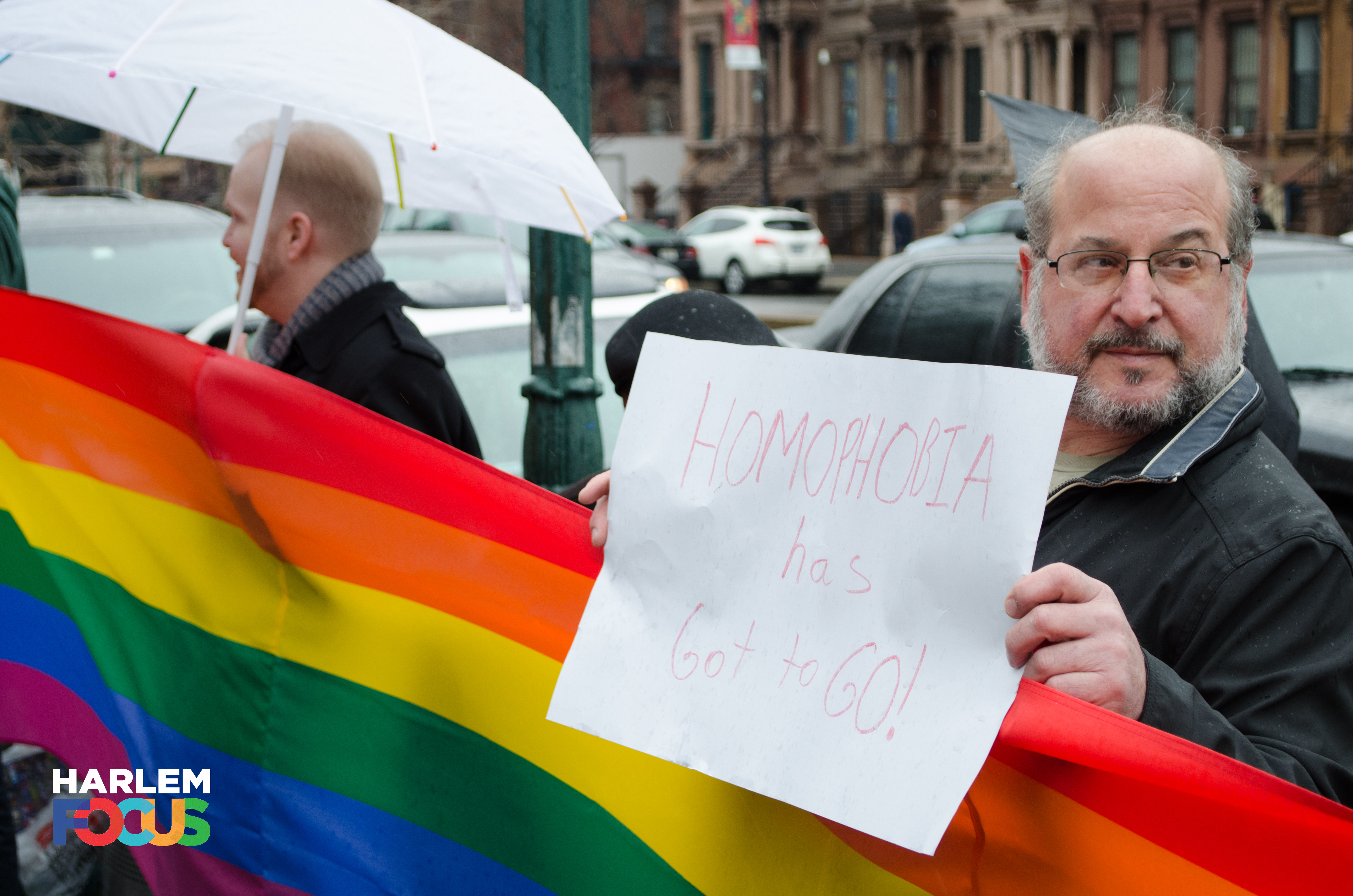 March 29th, 2014. Protester stands in the rain in front of ATLAH Church in West Harlem. His sign reads,